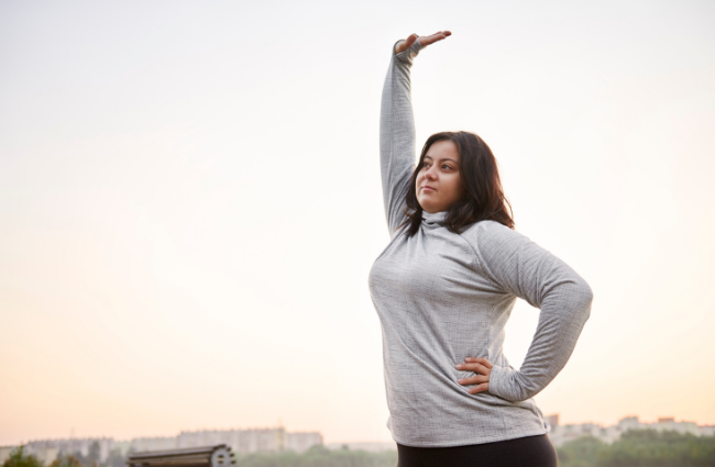 Getting back on the fitness wagon: Woman stretching outdoors