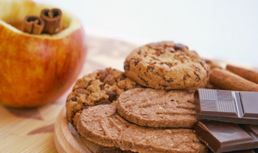 Example of natural vs added sugar: a cookie and chocolate next to an apple with cinnamon