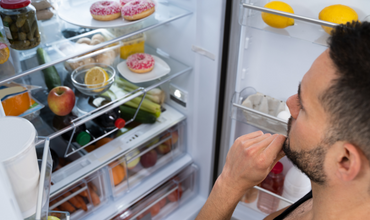 Hungry man looking inside refrigerator