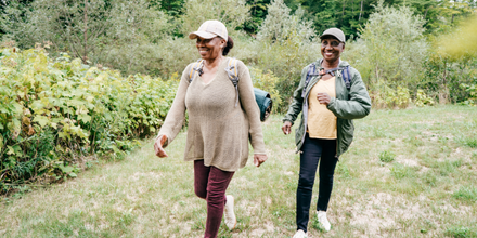 Photo of two African American women hiking outside and smiling, meant to depict the physical and mental benefits of exercise