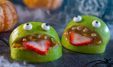Image of a healthy Halloween snack featuring green apple "monsters"