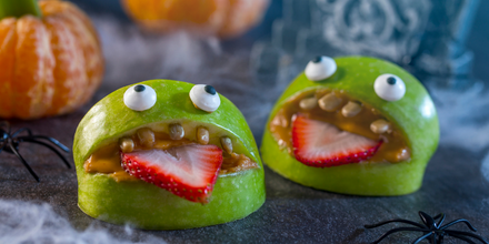 Image of a healthy Halloween snack featuring green apple "monsters"